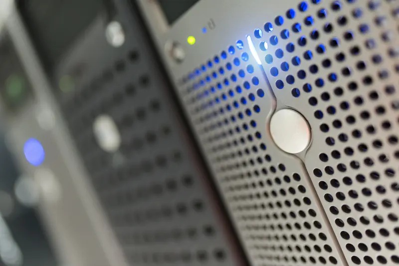 Close-up of a server rack with blue indicator lights and ventilation panels.