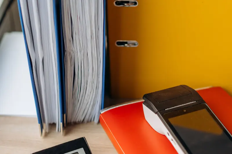 Upright folders, a notebook and a calculator on a desk.