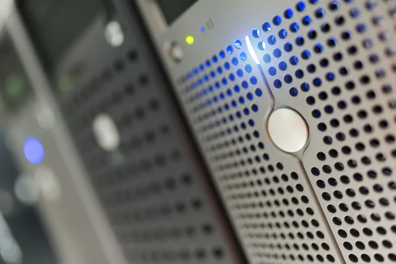 Close-up of a server rack with blue indicator lights and ventilation panels.